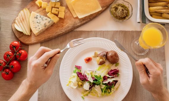 A vibrant lunch setting with salad, cheese, and orange juice, perfect for a healthy meal.