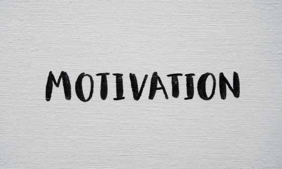 Inspirational word 'Motivation' in black on a white textured canvas background.